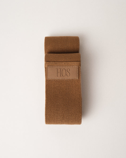 Sand color resistance band with HOS logo on a white background